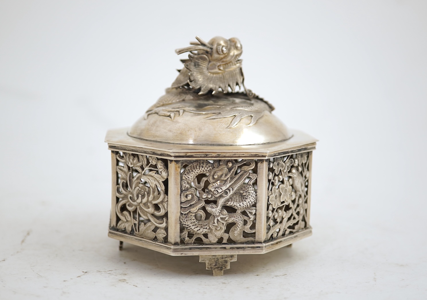 A late 19th century Chinese Export pierced silver card case, maker KMS(Kwong Man Shing), decorated with dragons amid clouds, 10.4cm, together with a Chinese Export pierced silver octagonal box and cover, by Luen Wo?, cir
